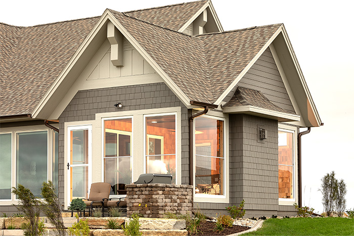 The exterior of a lovely home with a glass window sunroom